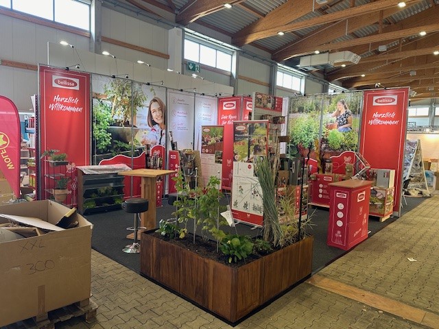 Messestand bellissa – Haas GmbH auf der Sagaflor in Kassel mit roten Markenflächen, Pflanzensortiment und Hochbeet-Präsentation